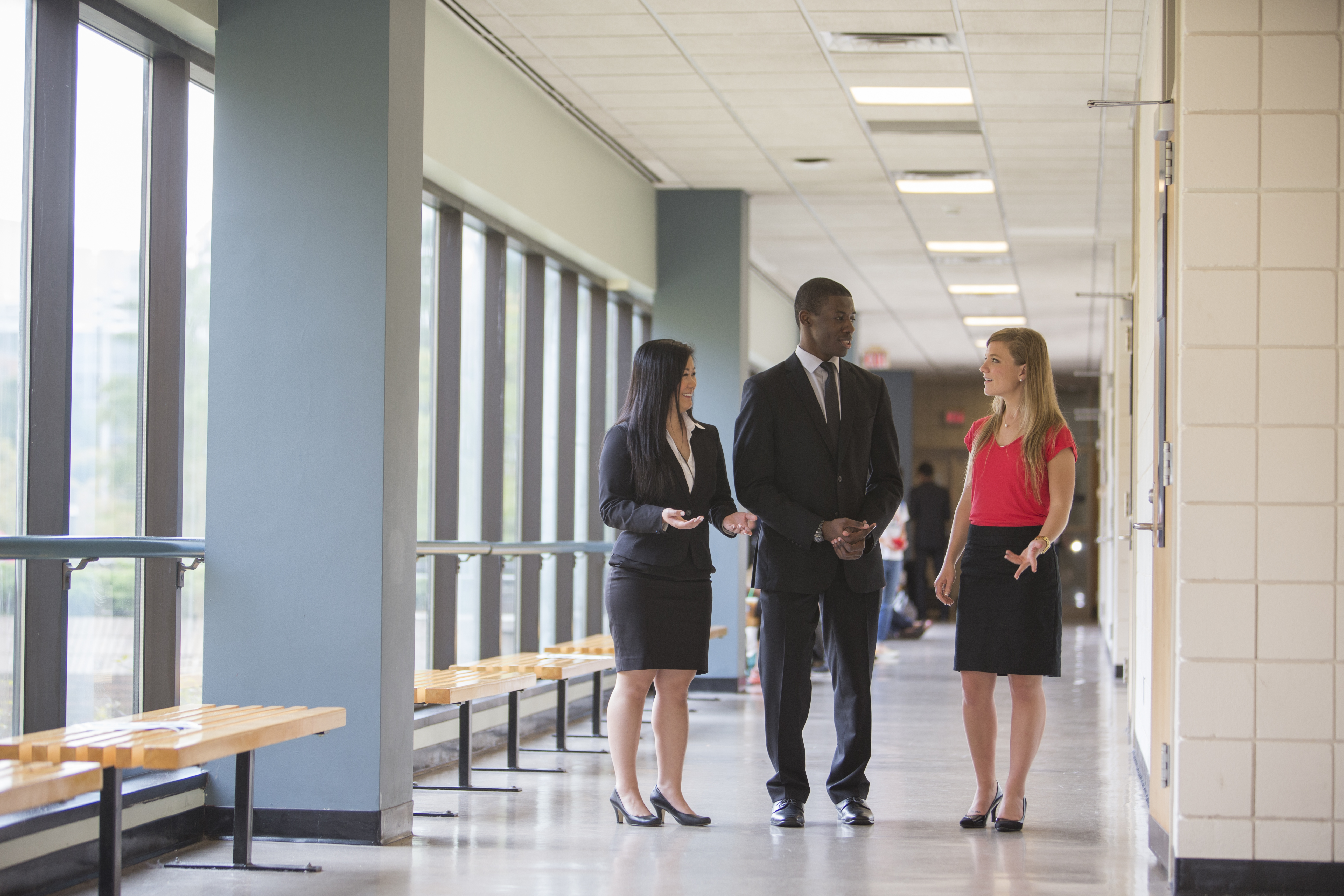 Professionals talking in a building hallway.