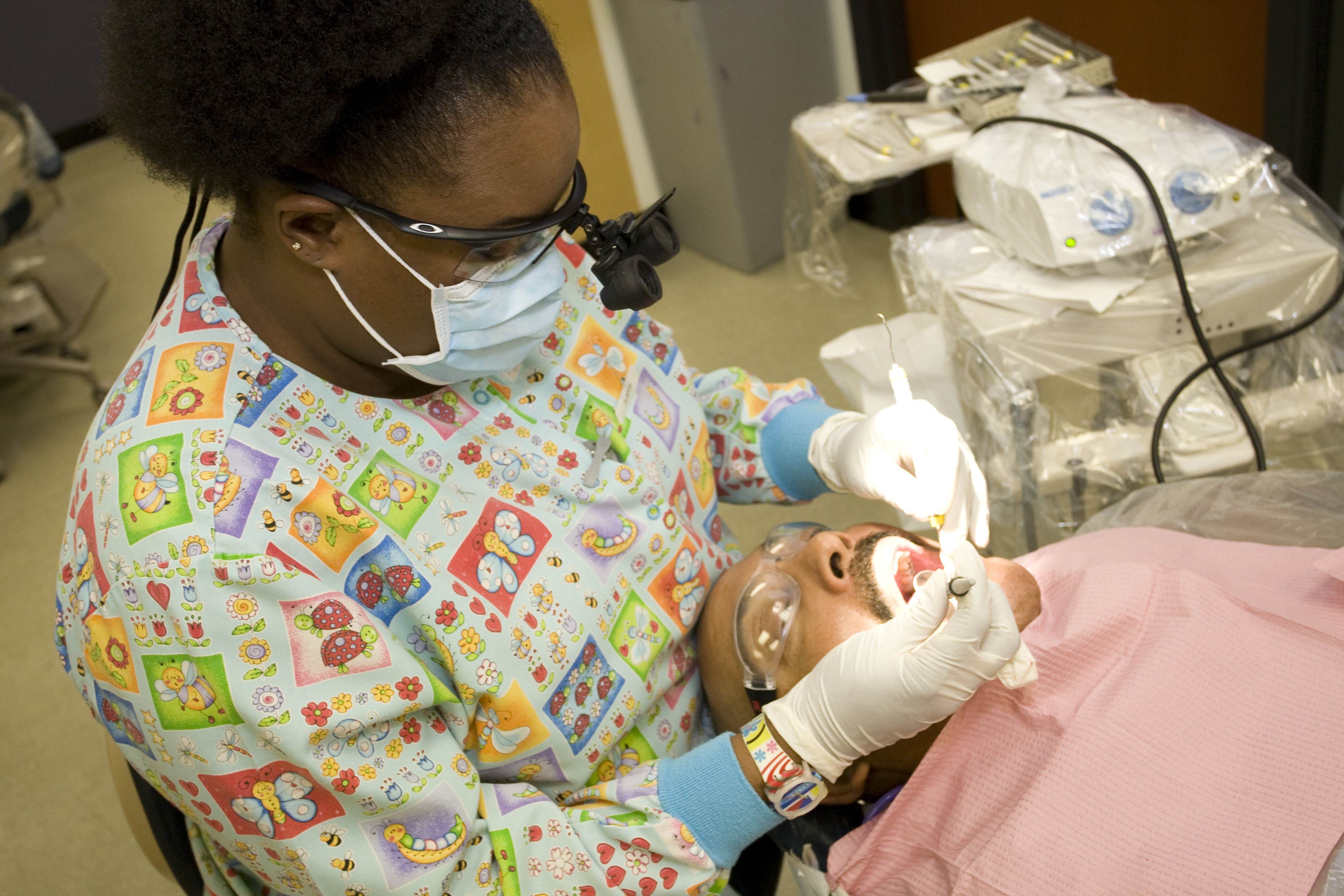 Dental professional performing a dental exam on a patient in a clinical setting