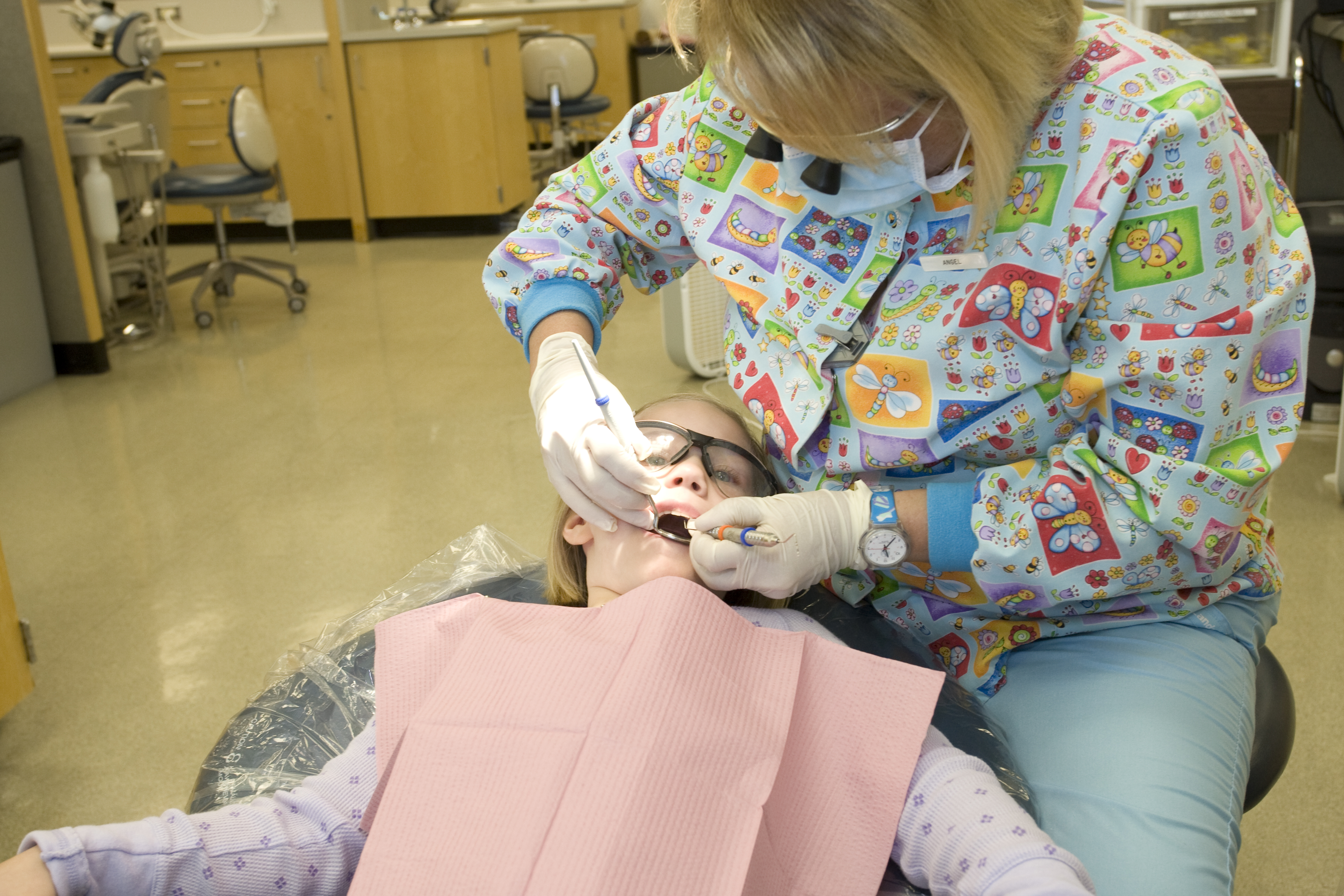 Dental professional providing care to a child patient in a dental clinic