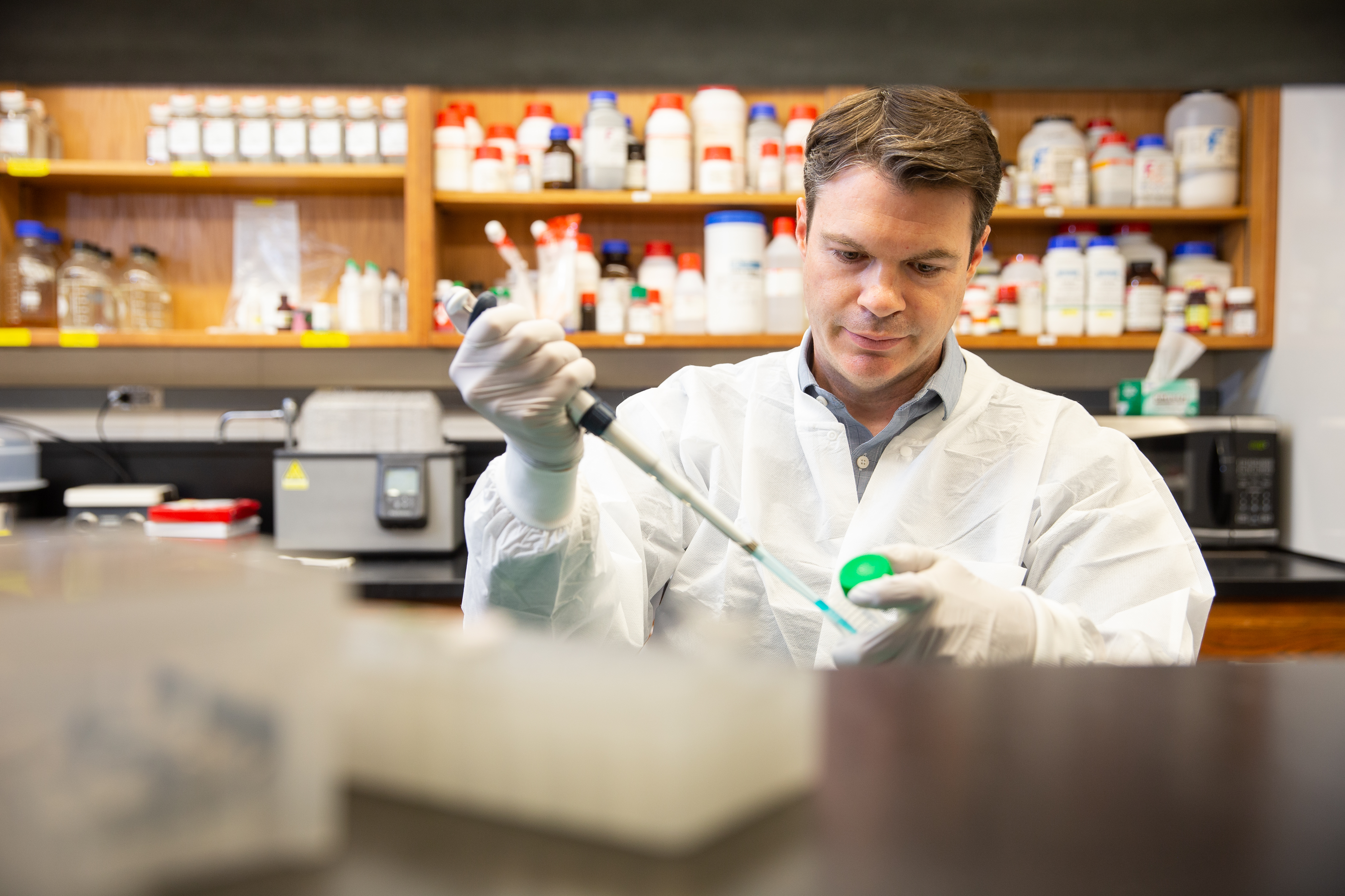 Researcher using a pipette to handle a sample in a laboratory