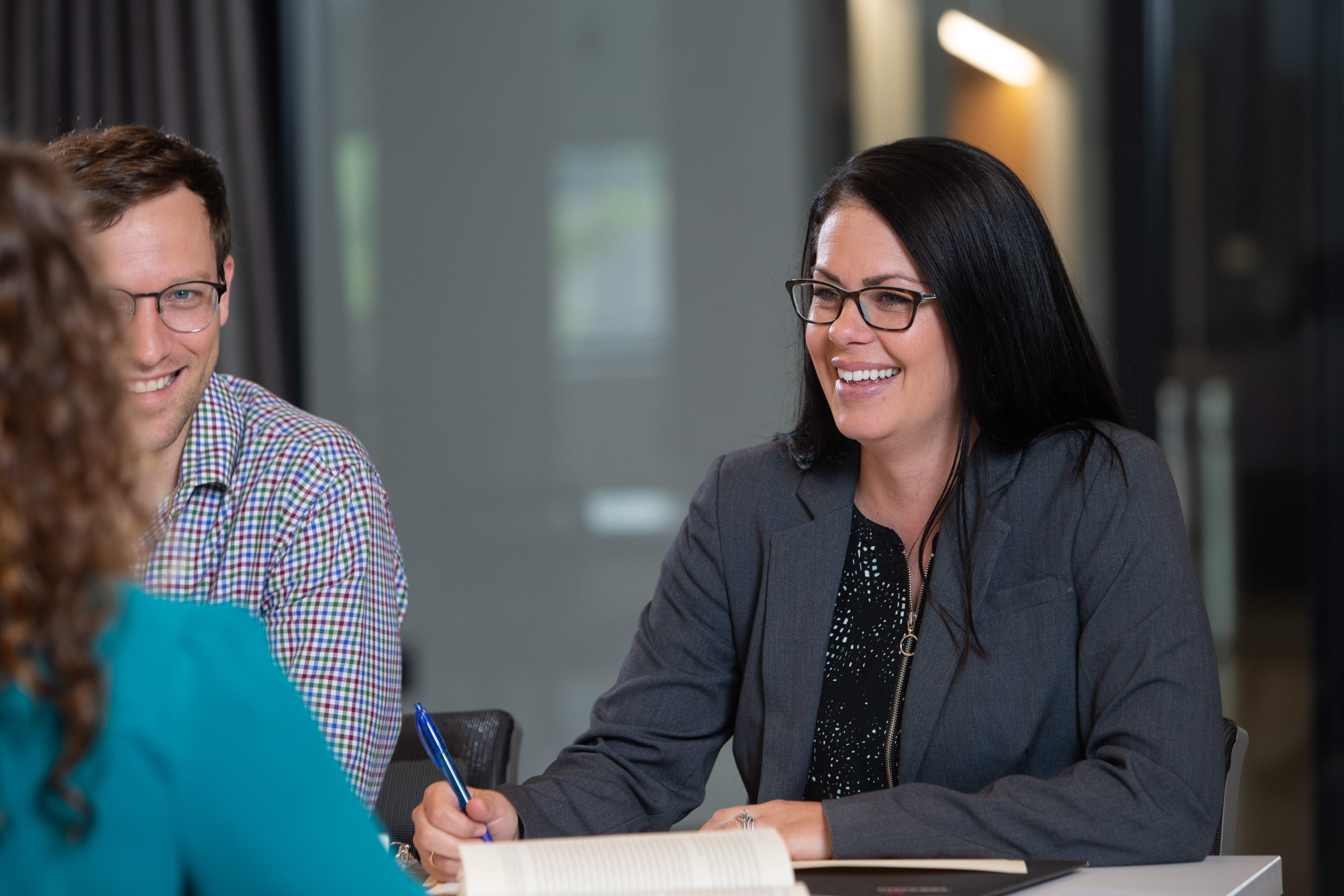 Professionals sitting around a table in a meeting.