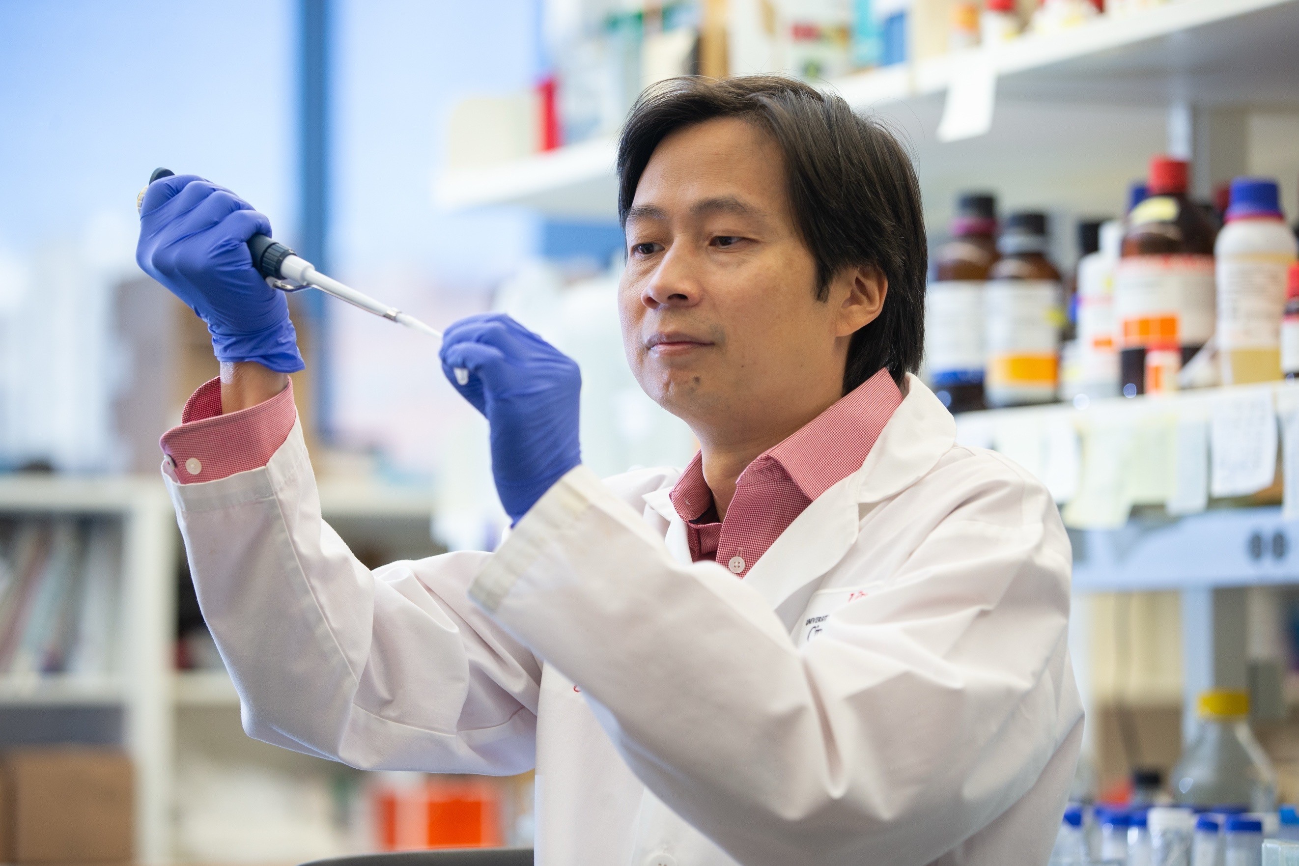A pharmacy or laboratory professional performs sample preparation using a pipette in a research laboratory