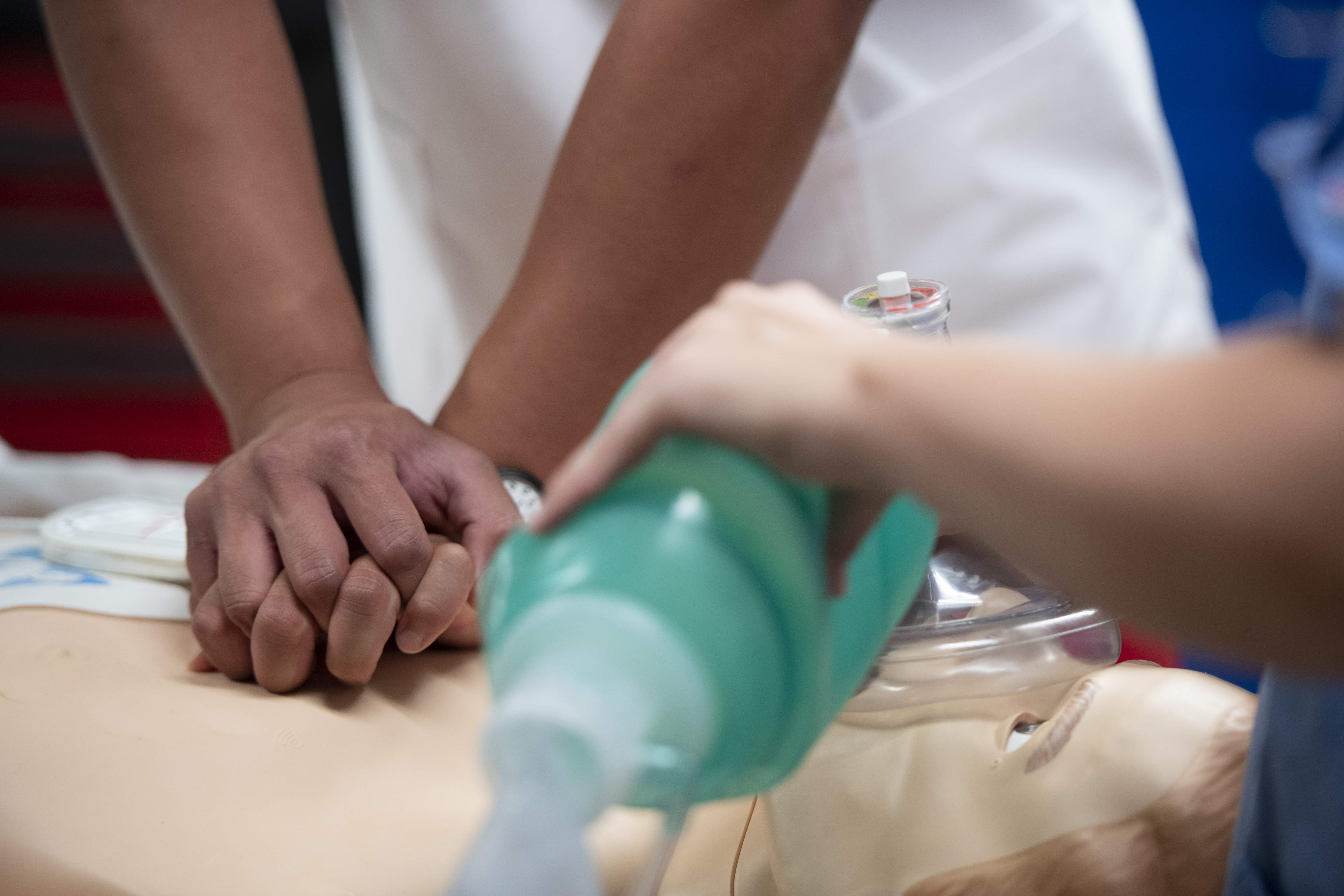 Medical team performing CPR and ventilation on a training mannequin