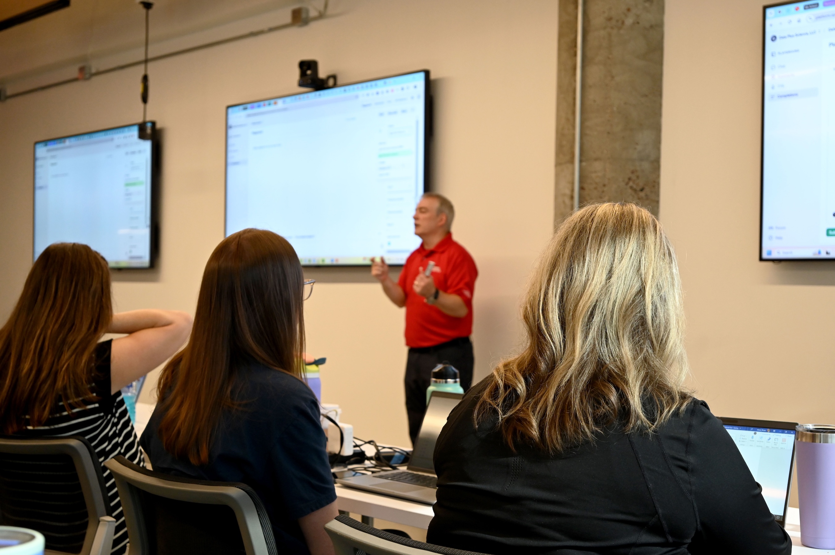 An instructor demonstrates Tableau to learners seated at computers during a classroom training session